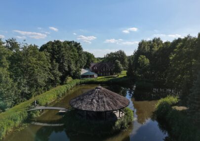 Lokal Przy Złotej Wyspie otoczony zielenią i stawem