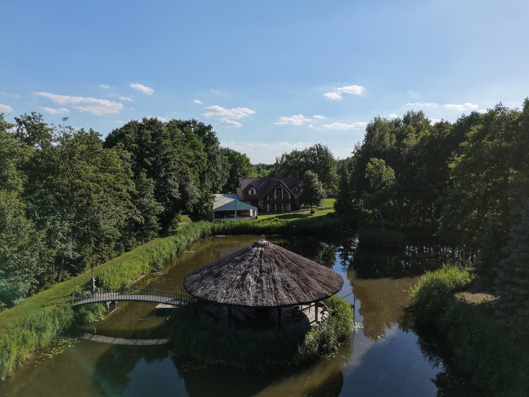 Lokal Przy Złotej Wyspie otoczony zielenią i stawem